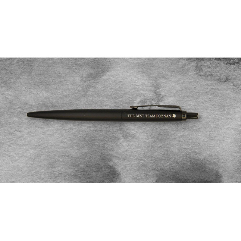 Czarny długopis Parker Jotter XL Monochrome z grawerem „THE BEST TEAM POZNAŃ” na szarym tle.