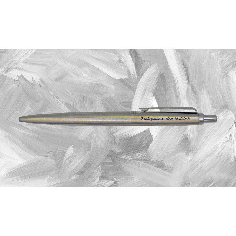 Srebrny długopis Parker Jotter XL Monochrome Stainless Steel z grawerem „Z podziękowaniem klasa 7B Zielonki” na tle pociągnięć białą farbą