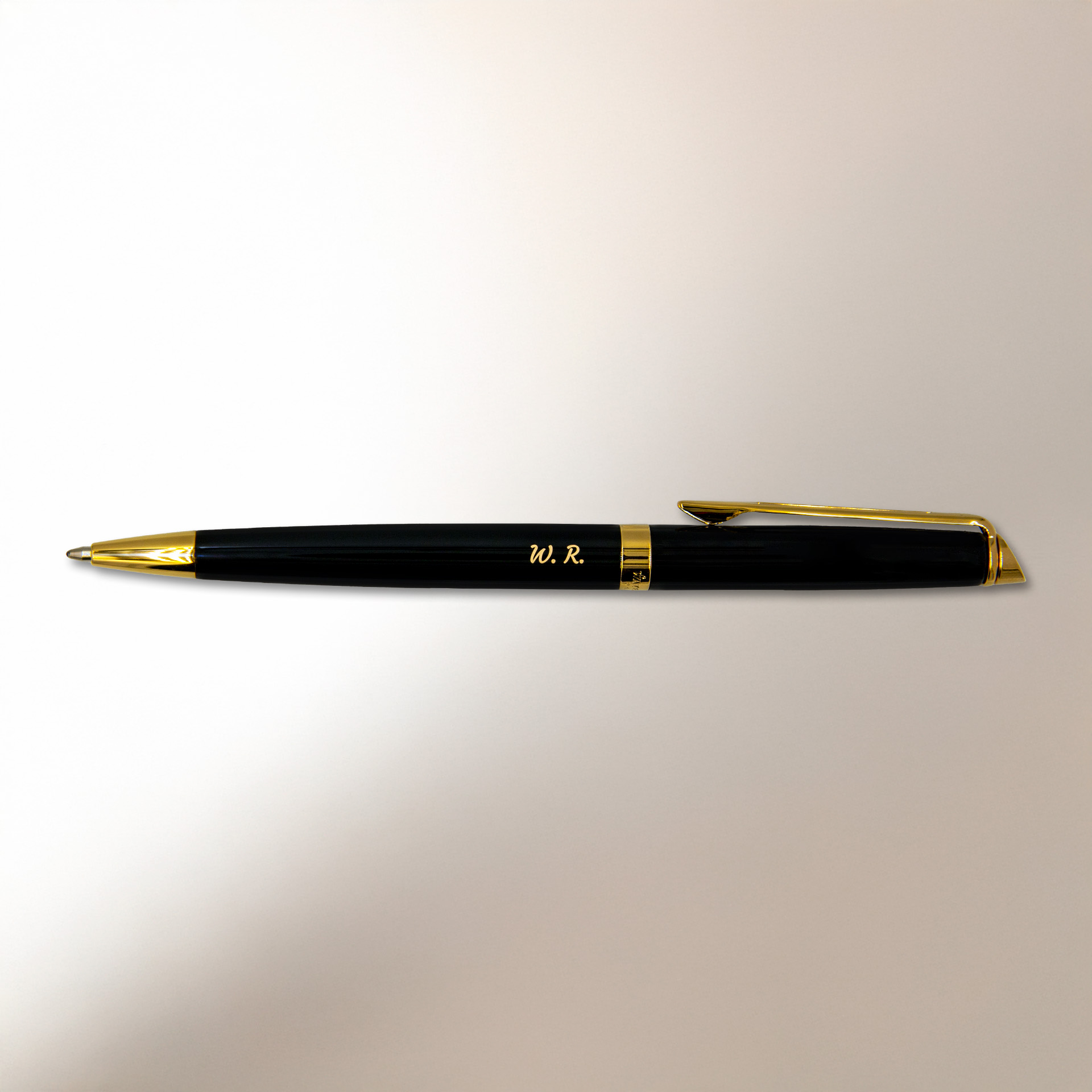 Długopis Waterman Hemisphere czarny GT (S0920670) z pozłacanymi wykończeniami i grawerem inicjałów „W.R.” na jasnym tle z miękkim światłem