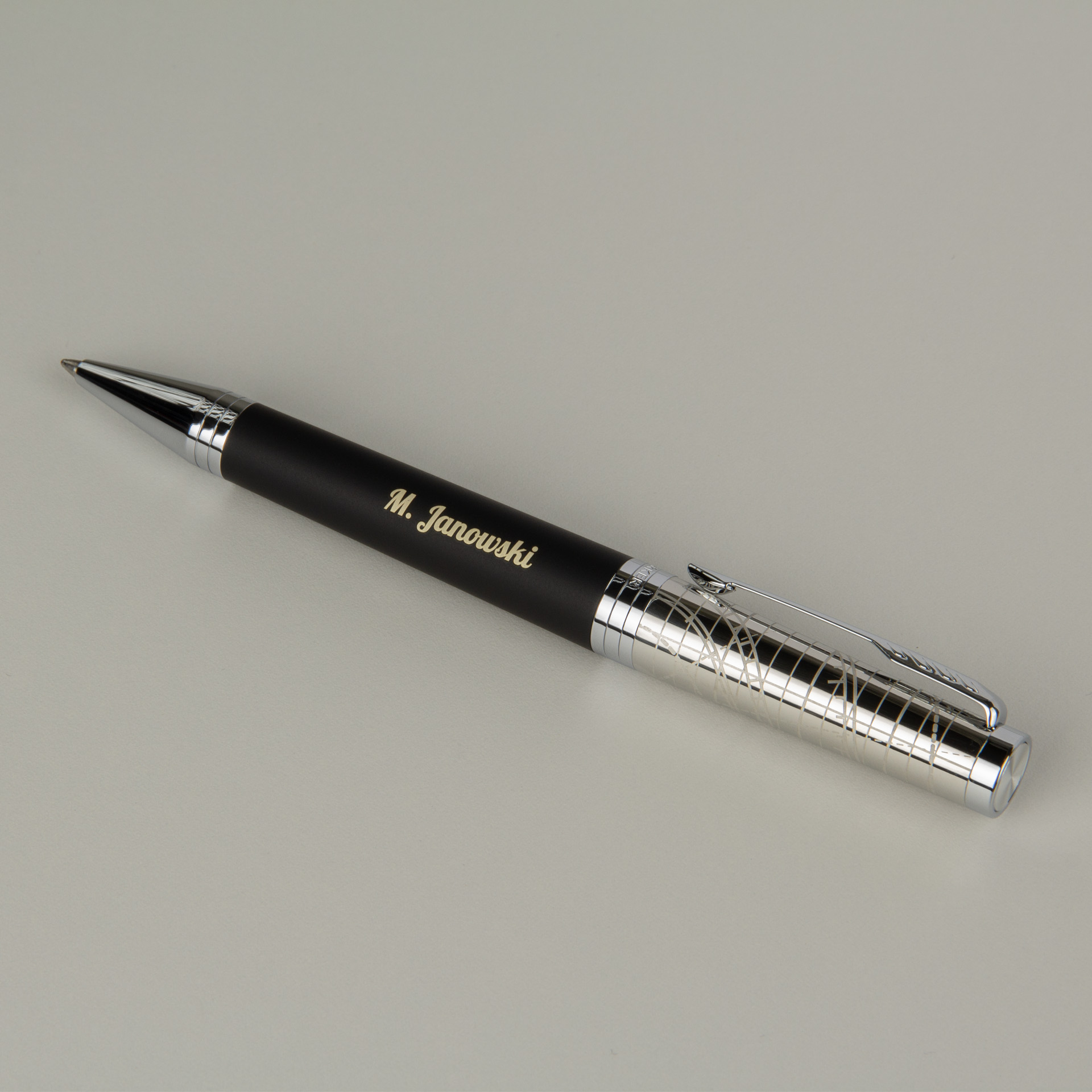 Elegancki czarny długopis z personalizowanym grawerem imienia, srebrne detale, minimalistyczny design premium