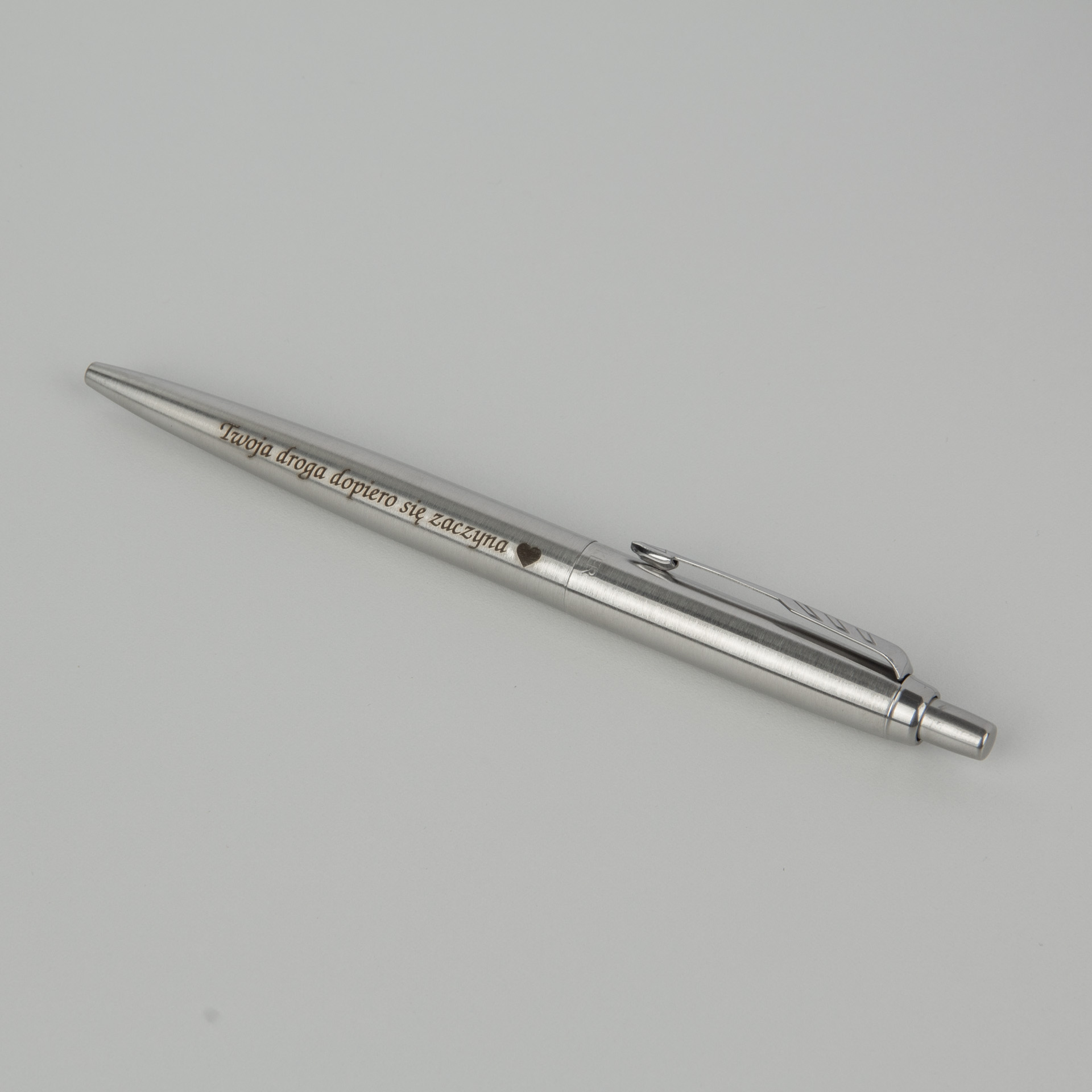 Srebrny długopis z personalizowanym grawerem dedykacji, elegancki minimalistyczny design, prezent z grawerem