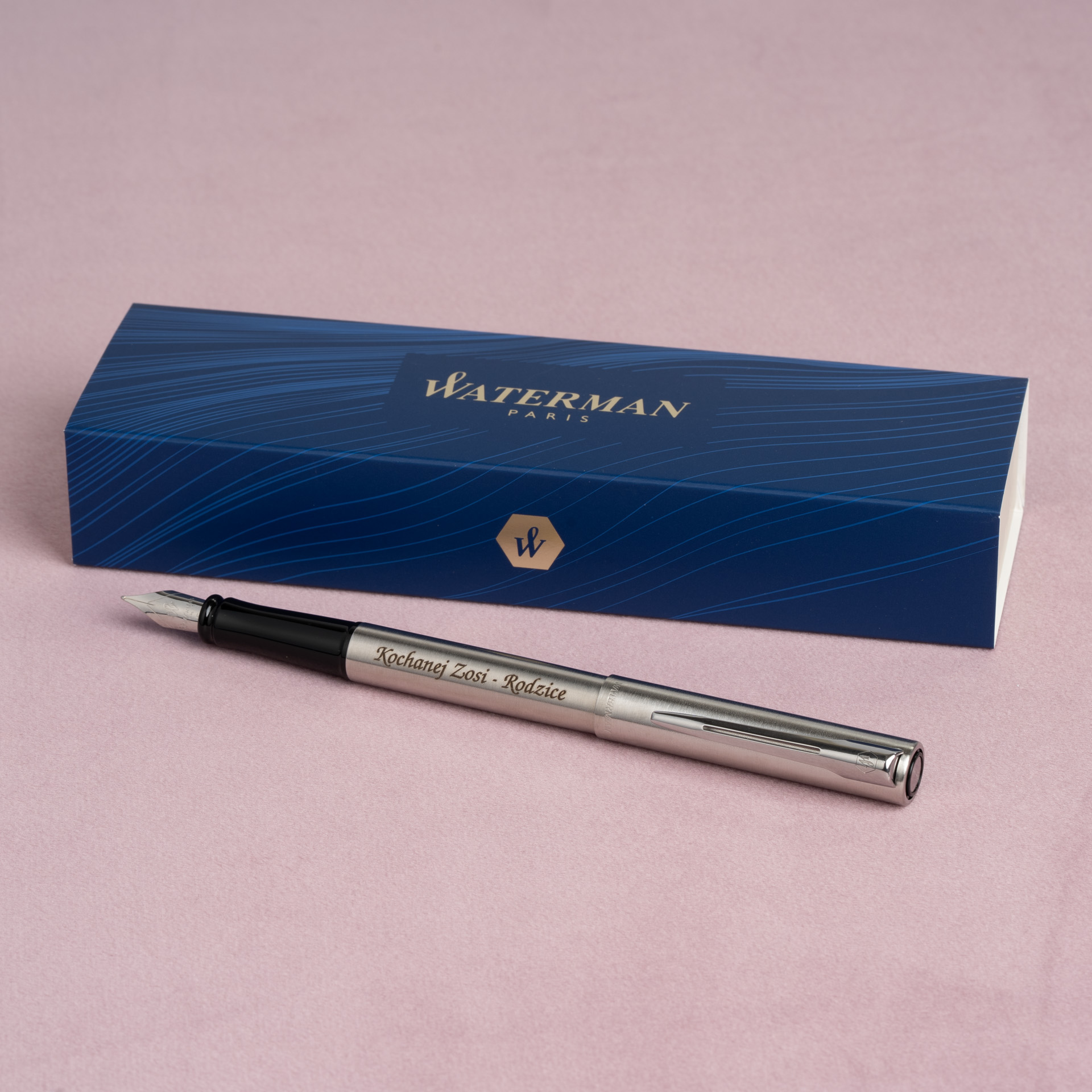 Pióro wieczne Waterman Allure stalowe CT z grawerem na tle etui Waterman.